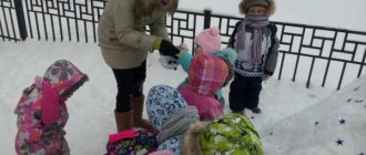 Дети и воспитатель в зимней одежде рассматривают снег