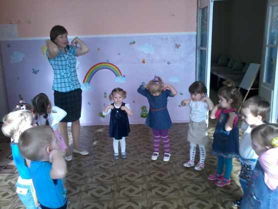 Children and teacher standing in a circle doing exercises