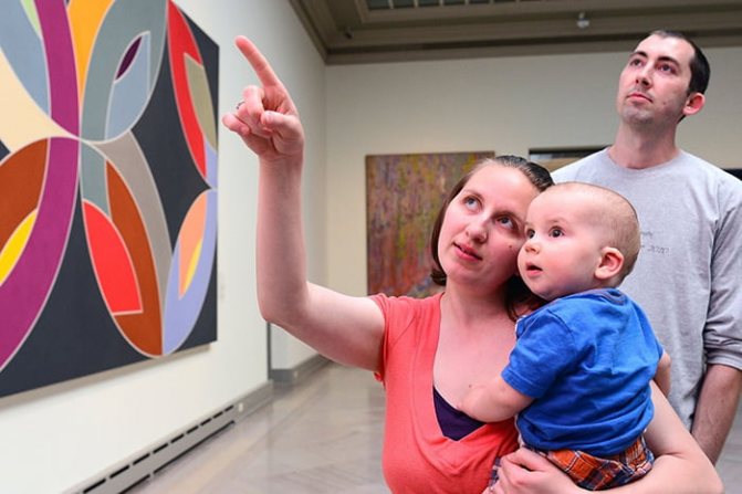 Baby in mother&#39;s arms in an art gallery