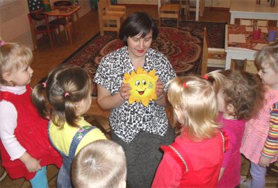 teacher shows children a toy