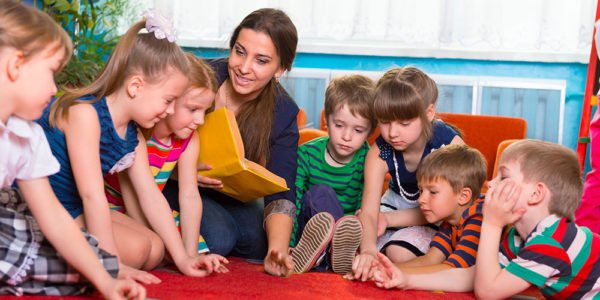 teacher reading a book to children